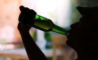 Silhouette of man drinking alcohol, close up