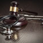 Gavel and Stethoscope on Reflective Table