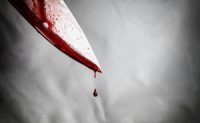 Closeup of a bloody knife with blood dripping